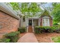 Inviting home entrance with brick walkway and manicured shrubbery at 134 Lawrence Tee Ln, Mooresville, NC 28117