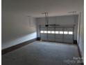 Spacious garage with ample room for storage, featuring a standard garage door and concrete flooring at 144 Mason Tanner Ct, Rock Hill, SC 29730