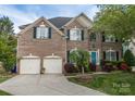 Charming brick home with a two-car garage and a bright blue front door at 15406 Pepperwood Ct, Huntersville, NC 28078