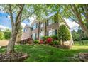 Brick home with well-maintained landscaping, colorful flowers, and a charming front entrance at 15406 Pepperwood Ct, Huntersville, NC 28078