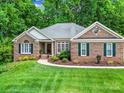 Charming brick home with well-maintained lawn and landscaping, featuring a welcoming entrance and classic design elements at 160 Fernbrook Dr, Mooresville, NC 28117