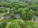 Scenic aerial view of a beautifully landscaped home nestled among mature trees in a serene neighborhood at 3015 Hamptonbrook Dr, Gastonia, NC 28056