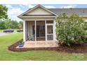 Inviting screened porch with a rocking chair and brick flooring overlooking a serene backyard at 31470 Royal Tern Ln, Indian Land, SC 29707