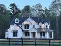 Stunning two-story home with inviting front porch and meticulous details, set against a backdrop of mature trees at 4095 Kingfisher Dr, York, SC 29745