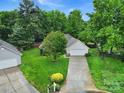 An elevated view of a cozy home with mature trees, landscaping, and a paved driveway on a cul-de-sac at 5009 Ravens Ct, Matthews, NC 28104