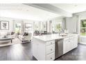 Open-concept kitchen with an island, stainless steel dishwasher, and adjacent living/dining areas at 522 Lenswood Ct, Denver, NC 28037