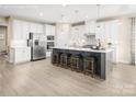 Bright, open kitchen features a large island with seating and stainless steel appliances at 521 Lenswood Ct, Denver, NC 28037