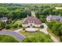 Grand home with a manicured lawn and landscape, complemented by an inviting entrance and circular driveway at 5400 Challisford Ln, Charlotte, NC 28226