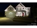 Beautiful two-story home featuring a well-lit exterior, charming porch, and a manicured front lawn at 6016 Willow Pin Ln, Huntersville, NC 28078