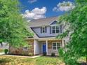 Inviting two-story home featuring stone accents, light grey siding and a bright blue front door at 6541 Hasley Woods Dr, Huntersville, NC 28078