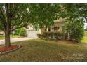 Charming home with a well-manicured front yard, mature trees, and an attached two-car garage at 9159 Marasol Ln, Concord, NC 28027