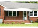 Close-up of the front porch featuring a white awning, brick detail, and security system at 925 Grace Ave, Lancaster, SC 29720
