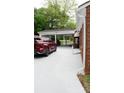 View of the parking area and carport with a red vehicle parked on the white lot at 925 Grace Ave, Lancaster, SC 29720