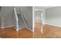 Inviting entryway with hardwood floors and a staircase, transitioning into a brightly lit living area at 9321 Bradstreet Commons Way, Charlotte, NC 28215