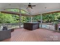 Relaxing screened porch with hot tub, seating, and serene backyard view at 9624 Barnburgh Ln, Huntersville, NC 28078