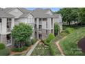 Exterior shot of a multi-story home with a walkway, manicured lawn and mature trees at 108 Pier 33 Dr # 414, Mooresville, NC 28117