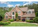 Charming two-story brick home with a beautifully manicured lawn and mature trees, offering great curb appeal and a welcoming ambiance at 118 Sunrise Cir, Mooresville, NC 28117