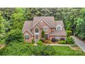 Beautiful brick home boasts lush landscaping, a well-manicured lawn, and mature trees, offering great curb appeal and a private setting at 118 Sunrise Cir, Mooresville, NC 28117