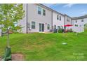 Backyard of the townhome featuring a well-manicured lawn, patio area, privacy fence, and outdoor seating at 12110 Chesapeake Mallard Dr, Charlotte, NC 28262