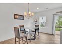 Cozy dining area with a glass table, stylish chairs, chandelier, and natural light from the window at 12110 Chesapeake Mallard Dr, Charlotte, NC 28262