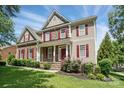 Charming two-story home with stone accents, red shutters and a well-manicured front lawn at 126 W Warfield Dr, Mooresville, NC 28115