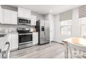 Bright kitchen features stainless steel appliances, white cabinets, and wood grain flooring at 1430 Samuel St, Charlotte, NC 28206