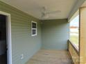 The covered back porch features wood flooring, green siding, ceiling fan, and natural lighting at 149 Mason Tanner Ct, Rock Hill, SC 29730