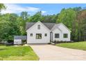 Bright, modern white farmhouse with an expansive driveway and lush green lawn at 184 Quiet Cove Rd, Mooresville, NC 28117