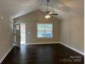 Bright living room with vaulted ceiling, ceiling fan, and dark hardwood flooring at 196 Bradley St, Wadesboro, NC 28170