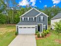 Beautiful two-story home with a well-kept lawn, complemented by lush greenery, with an attached two-car garage at 2012 Slippery Rock Ln, Monroe, NC 28112