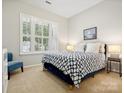 Cozy bedroom featuring a patterned bedspread, a window with shutters, and soft, neutral carpeting at 3068 Streamhaven Dr, Lancaster, SC 29707