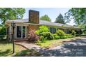Beautiful ranch-style home with stone facade, brick chimney, and manicured landscaping, perfect curb appeal at 3418 Sulphur Springs Ne Rd, Hickory, NC 28601