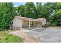 Exterior shot of the home featuring a red roof, siding, and a cozy front porch at 3690 Birchwood Ln, Denver, NC 28037
