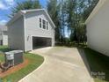 Detached gray garage featuring a concrete driveway, window, siding and a peek of the trees at 4021 Grommet Ct, Matthews, NC 28105