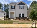 Two-story home featuring stone accents, gray siding, black shutters, and a manicured front yard at 4025 Grommet Ct, Matthews, NC 28105