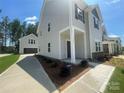 Exterior view showcasing a two-story home with a detached garage, featuring neutral siding and a covered porch at 4025 Grommet Ct, Matthews, NC 28105