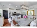 Open kitchen featuring white cabinets, granite countertops, stainless steel appliances, and a dining area at 4038 Zilker Park Dr, Charlotte, NC 28217