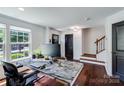 Home office showcasing dark wood floors, modern desk, and plenty of natural light and a staircase at 4038 Zilker Park Dr, Charlotte, NC 28217
