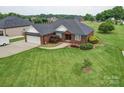 Spacious red brick home with an attached garage, lush green lawn, and well-maintained landscaping at 4618 Dallas High Shoals Hwy, Dallas, NC 28034