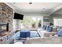 Comfortable living room with a stone fireplace, television, French doors to the deck, and ample seating at 46827 Tall Whit Rd, New London, NC 28127