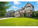 Beautiful two-story home with stone accents, three-car garage and lush green lawn at 5105 Paisano Ln, Waxhaw, NC 28173