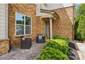 Inviting front patio with brick detail, cozy seating, and manicured greenery at 5105 Paisano Ln, Waxhaw, NC 28173
