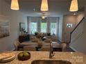 An open-concept dining and living room with hardwood floors and large bright windows at 5817 Tuckaseegee Rd, Charlotte, NC 28208