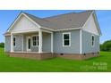 The back exterior with brick foundation, covered porch and lovely blue vinyl siding at 6203 Flay Rd, Cherryville, NC 28021
