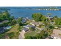 Stunning aerial view of a lakeside property with mature trees, a pool, and multiple docks at 8005 Island View Ct, Denver, NC 28037