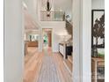 Elegant entryway featuring a hardwood floor, staircase with black railings, and modern light fixture at 8108 Farm Crossing Ln # 26, Huntersville, NC 28078