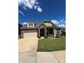 Charming home with stone accents, a two-car garage, and a well-manicured lawn on a sunny day at 10039 St Kitts Landing Ln, Charlotte, NC 28278
