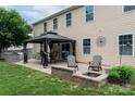 Backyard patio featuring an outdoor kitchen, gazebo, fire pit, and space for entertaining at 109 Meadow Stream Dr, Mount Holly, NC 28120