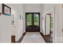 Inviting foyer with a dark wood double door entry and views of the backyard at 112 Nautilus Ct, Troutman, NC 28166