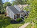 This home features a well-manicured lawn, brick accents and a tree providing shade and curb appeal at 11515 Retriever Way, Charlotte, NC 28269